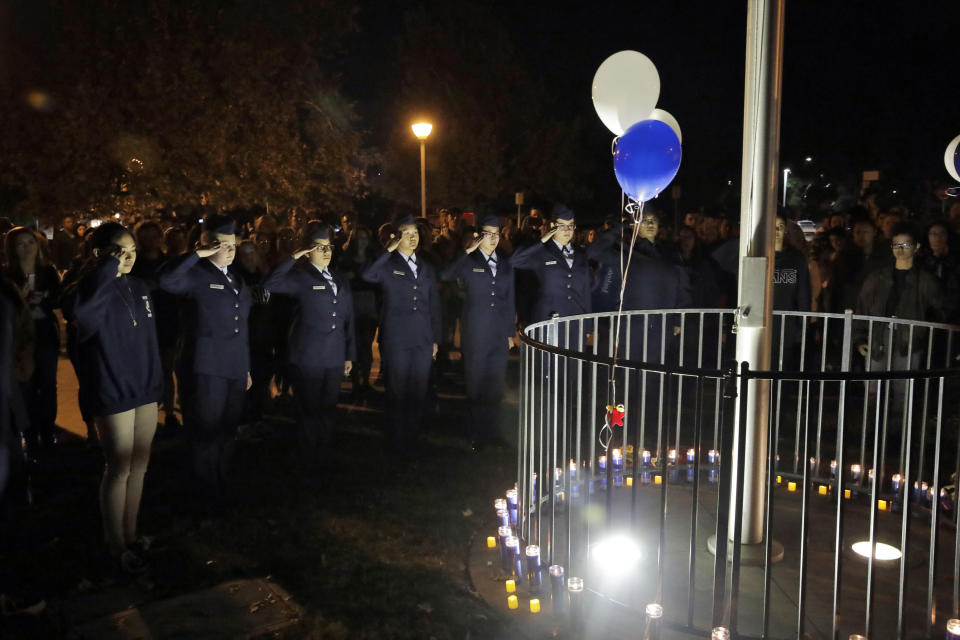 Members of Saugus High School's Air Force JUNIOR ROTC unit make a military salute in memory of the victims of a shooting at the school earlier in the day Thursday, Nov. 14, 2019, in Santa Clarita, Calif. (AP Photo/Marcio Jose Sanchez)