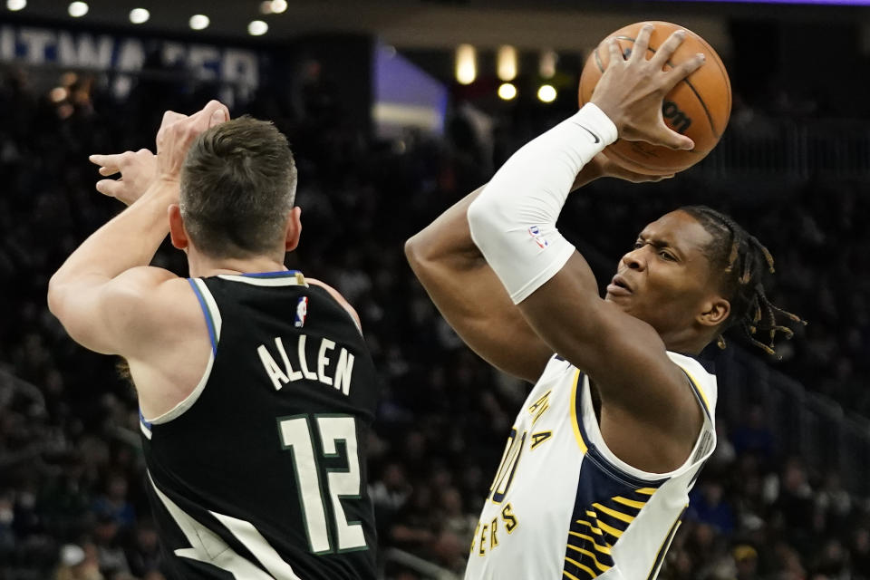 Indiana Pacers' Bennedict Mathurin, right, drives to the basket against Milwaukee Bucks' Grayson Allen during the first half of an NBA basketball game, Monday, Jan. 16, 2023, in Milwaukee. (AP Photo/Aaron Gash)