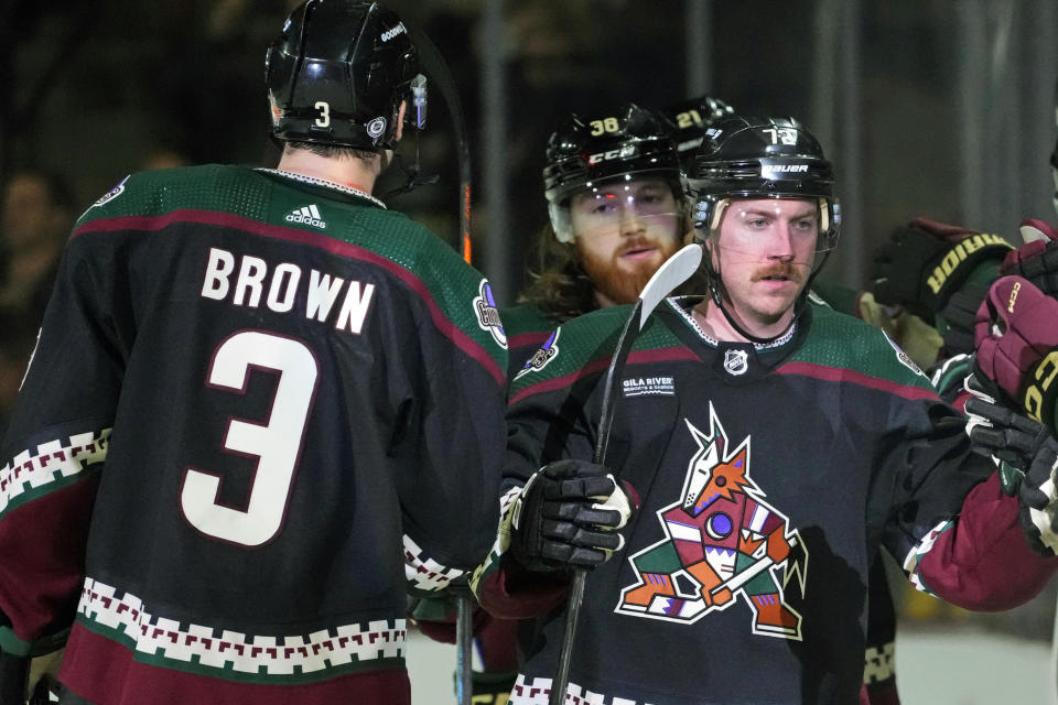 Arizona Coyotes center Travis Boyd celebrates his goal against the Tampa Bay Lightning as Coyotes defenseman Josh Brown (3) and Coyotes center Liam O'Brien (38) look on during the second period of an NHL hockey game Tuesday, Nov. 28, 2023, in Tempe, Ariz. (AP Photo/Ross D. Franklin)