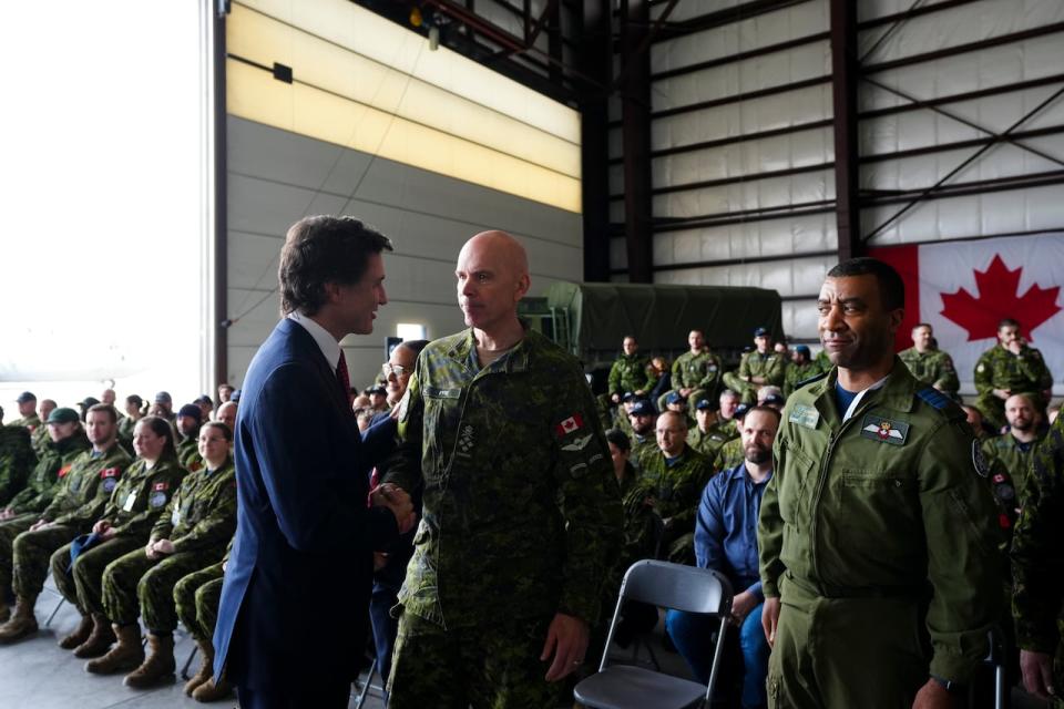 Prime Minister Justin Trudeau shakes hands with Chief of the Army Staff Wayne Eyre following a press conference on Canada's new defence policy, Monday, April 8, 2024, at CFB Trenton in Trenton, Ontario.