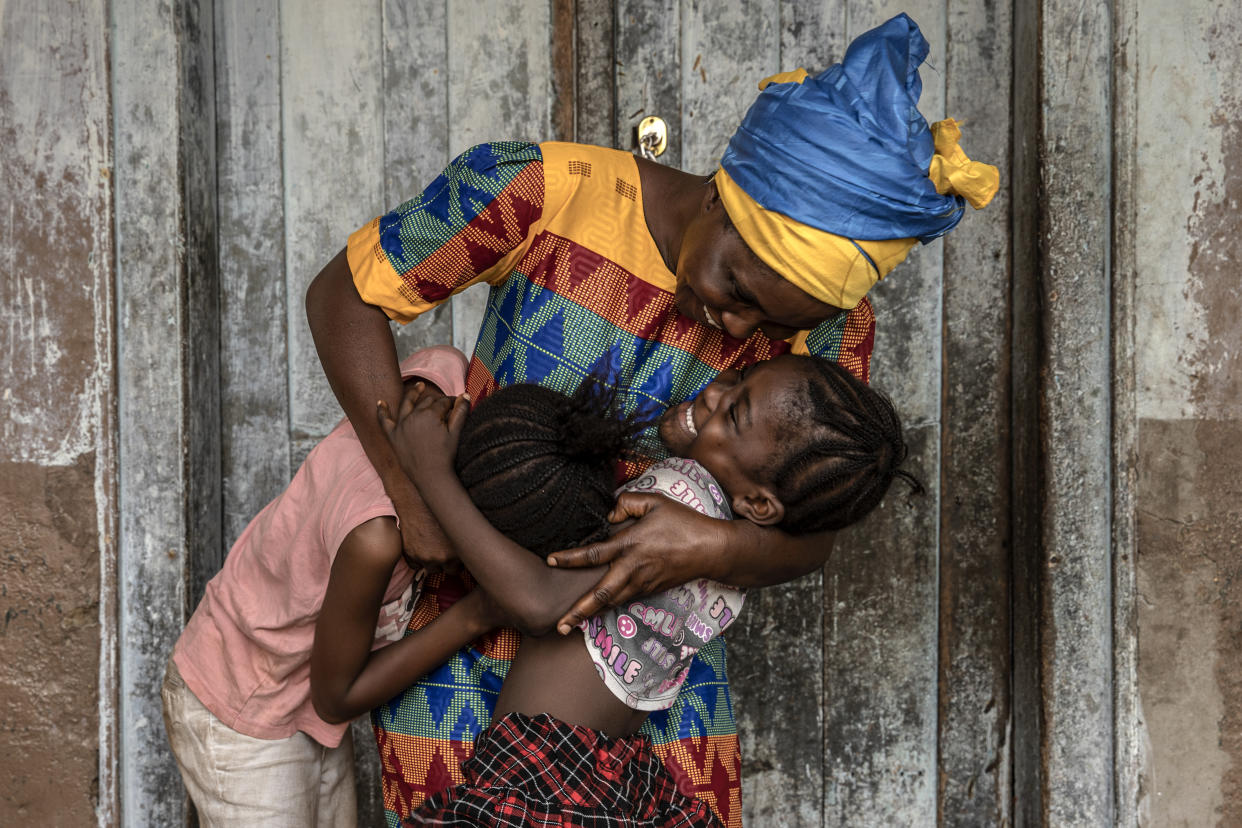 Kadiatu Bangora abraza a sus hijas, Adama y Mariama, en Port Loko, Sierra Leona, 20 de febrero de 2022. (Finbarr O’Reilly/The New York Times)
