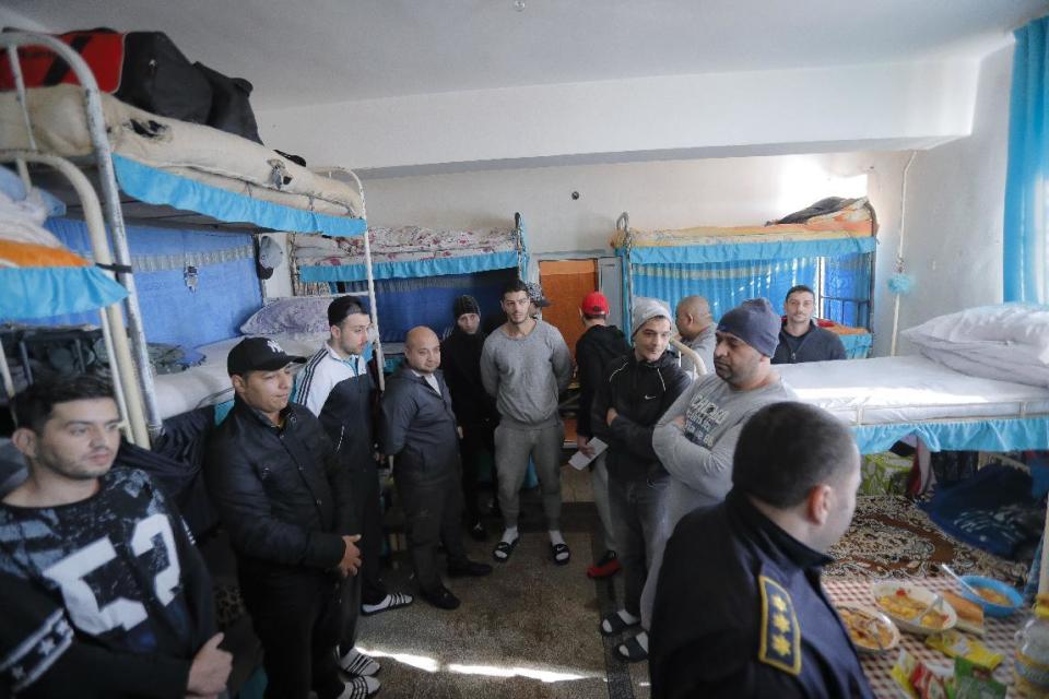 In this photo taken on Tuesday, Jan. 31, 2017, inmates stand inside a cell at the Jilava prison, in Jilava, Romania. Romania's government decriminalized official misconduct overnight Wednesday Feb. 1, 2017, defying mass protests and warnings from prosecutors and the president that the move will reverse the country's fight against corruption. (AP Photo/Vadim Ghirda)