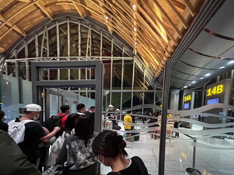 People queuing to go through an airport gate.