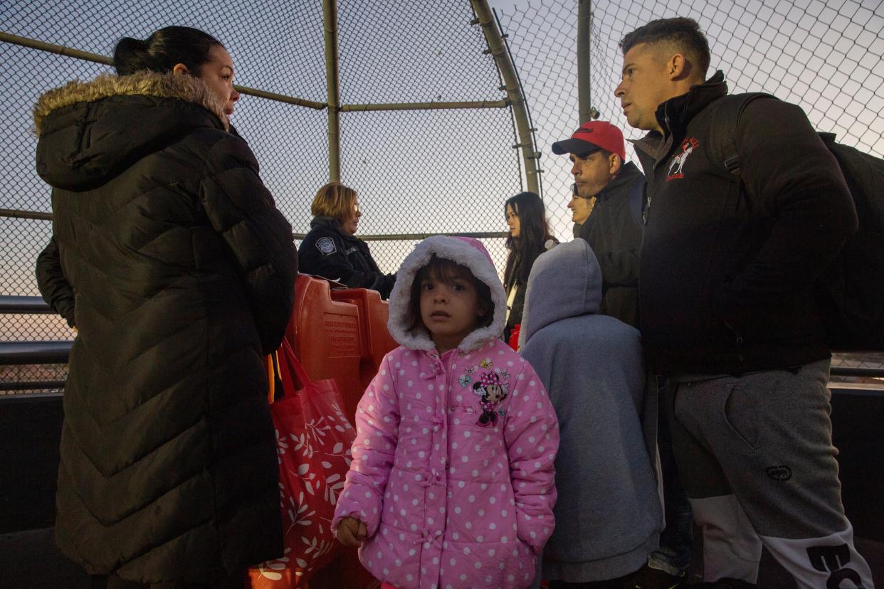 The Hernandez family, from Cuba, await be processed at the Paso Del Norte International Bridge as they present themselves after receiving an appointment via the CPB One on Dec. 14, 2023.