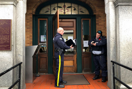 Canadian border officers inspect passports of Iranian citizens reuniting with family members at the Haskell Free Library and Opera House, which straddles the U.S.-Canada border in Stanstead, Quebec and in Derby Line, Vermont, U.S., November 3, 2018. Picture taken November 3, 2018. REUTERS/Yeganeh Torbati