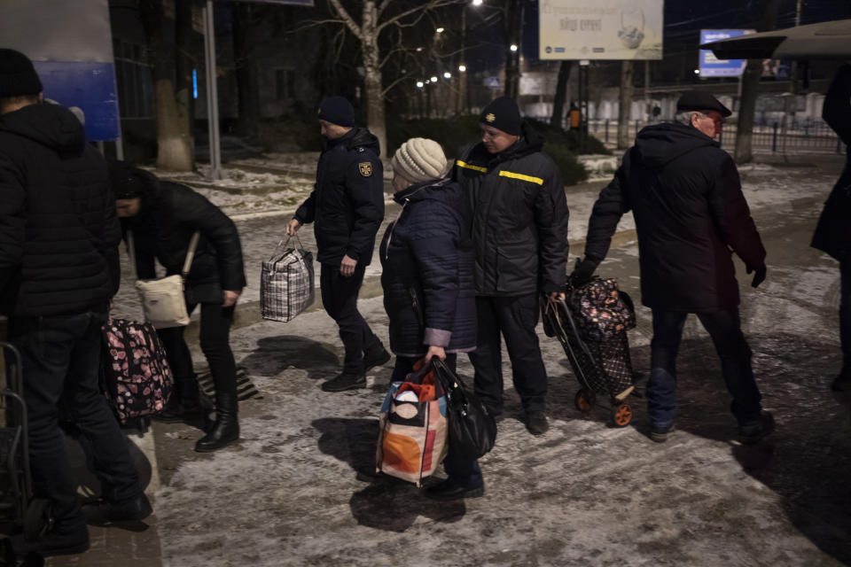 People carry their luggage before boarding an evacuation train in Sumy, Ukraine, Thursday, Nov. 23, 2023. An average of 80-120 people return daily to Ukraine from territories held by Russia through an unofficial crossing point between the two countries amid a brutal war. Most choose this challenging path, even in freezing temperatures, to escape Russian occupation and reunite with their relatives in Ukraine. (AP Photo/Hanna Arhirova)