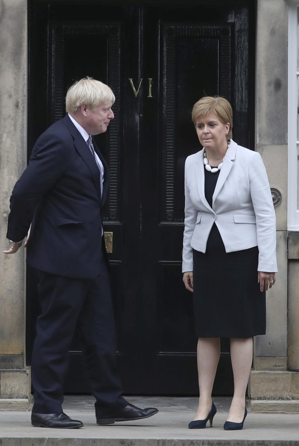 Scotland's First Minister Nicola Sturgeon, right, welcomes Britain's Prime Minister Boris Johnson, outside Bute House, ahead of their meeting, in Edinburgh, Scotland, Monday July 29, 2019. Johnson made his first official visit as British prime minister to Scotland, pledging to boost "the ties that bind our United Kingdom" amid opposition from Scottish leaders to his insistence on pulling Britain out of the European Union with or without a deal. (Jane Barlow/PA via AP)