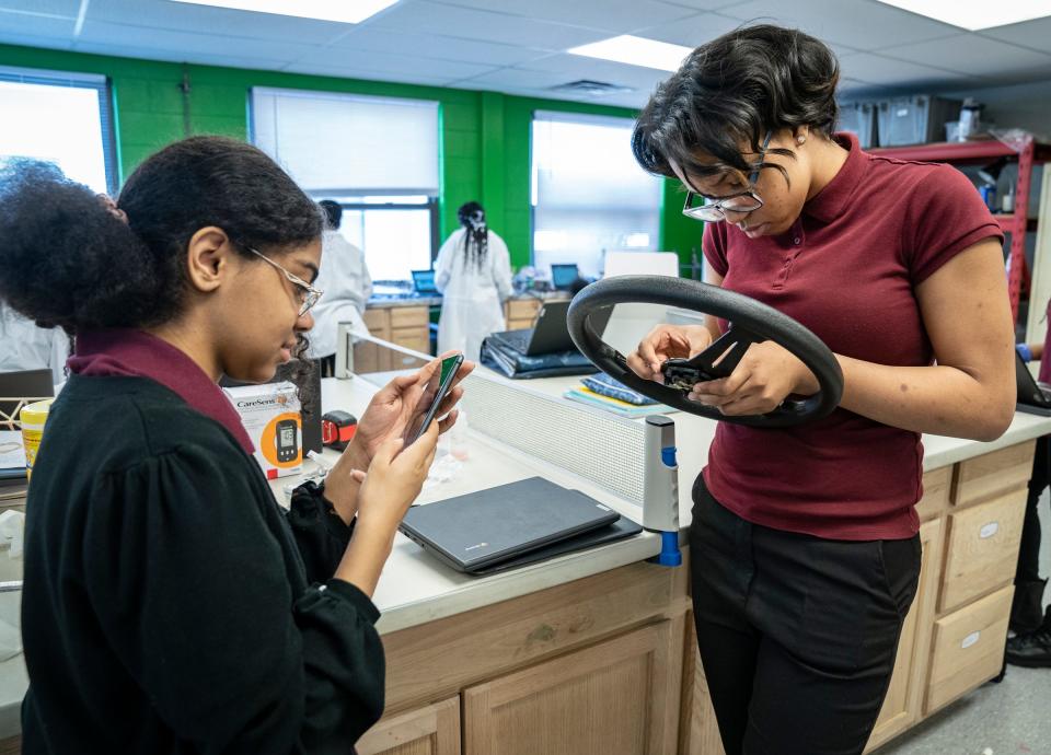 Students Nina Martinez, 15, a ninth grader, left, and her lab partner Antashia Davis, 14, a ninth grader, work together on a project together in the Ecotek Lab at American International Academy Jr. and Sr. High School in Inkster on Wednesday, March 8, 2023. The two were constructing a steering wheel that could take your vital signs while driving.