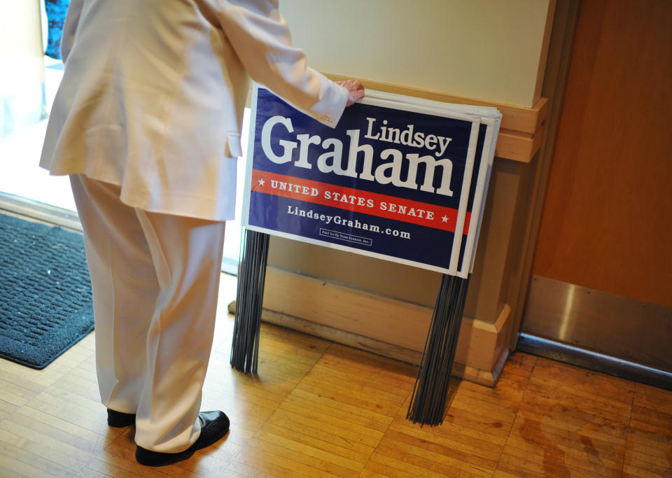 Helen Spiller takes a campaign sign for Sen. Lindsey Graham during a campaign stop at American Legion Post 20 on Wednesday, April 23, 2014, in Greenwood, S.C. (AP Photo/Rainier Ehrhardt)