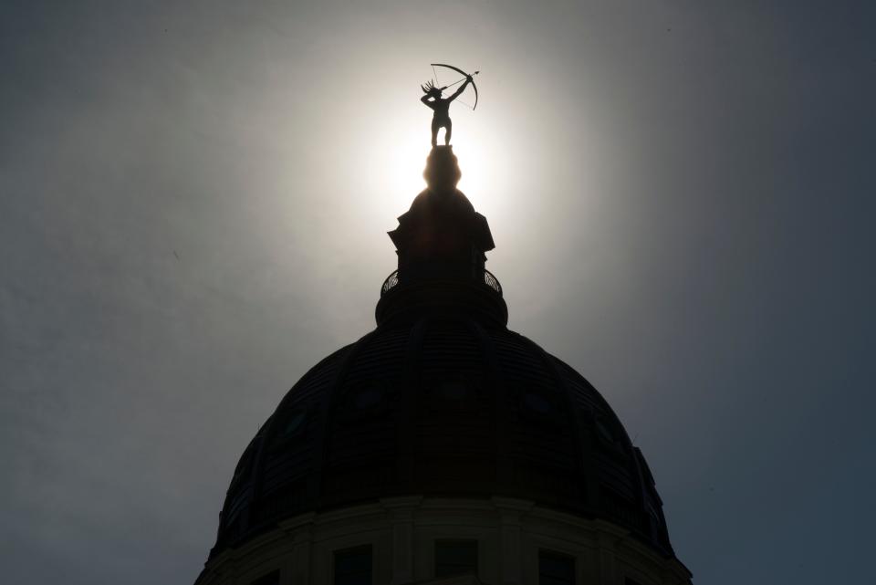 "Ad Astra," the bronze statue of a Kansa warrior, is silhouetted atop the dome of the Kansas Statehouse. A smaller replica was intended to sit on the Capital grounds.