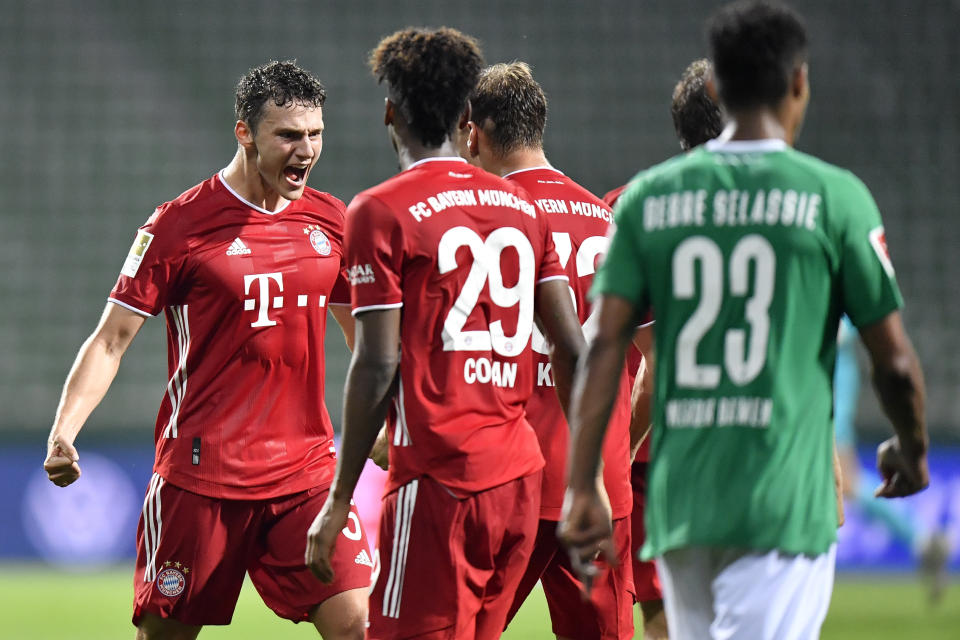 Bayern's Benjamin Pavard, left, celebrates with his teammates Bayern's Kingsley Coman and Bayern's Joshua Kimmich end of the German Bundesliga soccer match between Werder Bremen and Bayern Munich in Bremen, Germany, Tuesday, June 16, 2020. Because of the coronavirus outbreak all soccer matches of the German Bundesliga take place without spectators. Bayern Munich secured its eighth successive German Bundesliga title Tuesday with two games to spare after beating Werder Bremen 1-0 with a goal from Robert Lewandowski. (AP Photo/Martin Meissner, Pool)