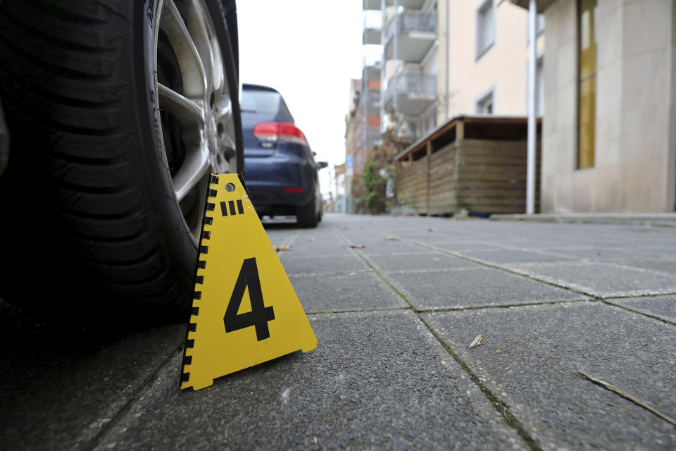 A mark of the forensic team of the police sits on a street in the St. Johannis district in Nuremberg, southern Germany, Friday, Dec. 14, 2018 where three women had been stabbed and wounded the evening before. (Daniel Karmann/dpa via AP)