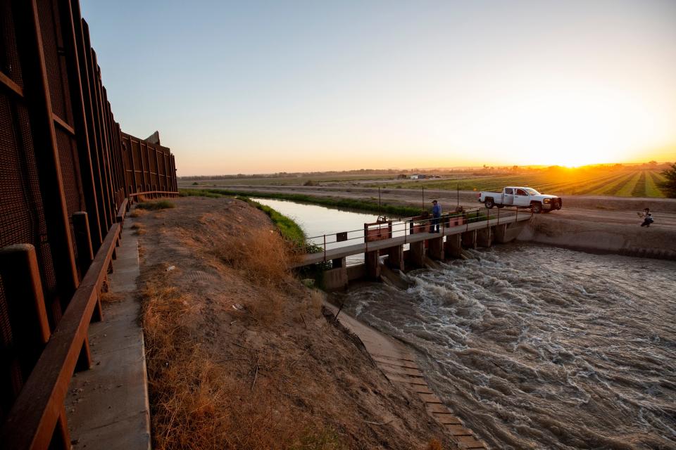 Robert Rios, water master for the El Paso County Water Improvement District No. 1 inspects a water canal near the border wall during a shift in July 2023.