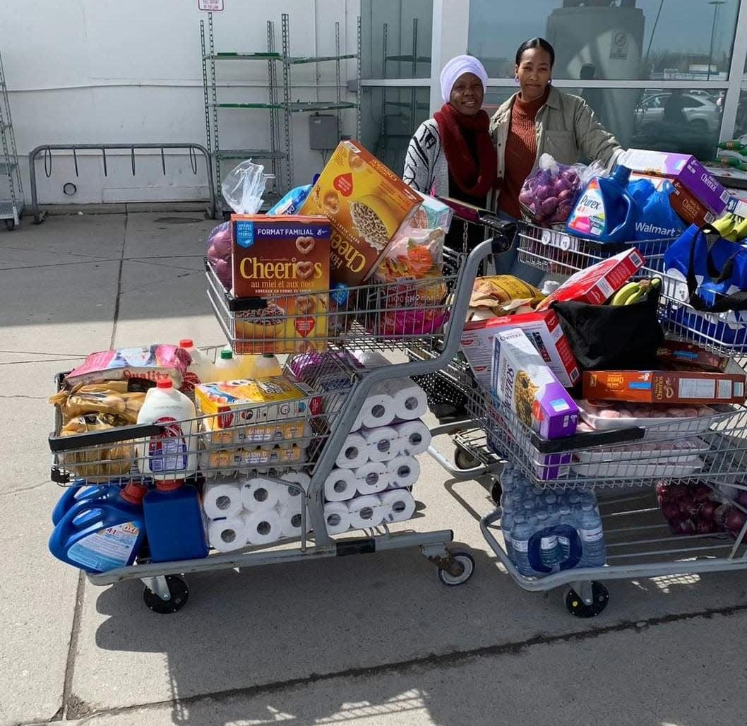 Members of the United African Diaspora mutual aid group stand with gathered food for the people they serve. (United African Diaspora - image credit)
