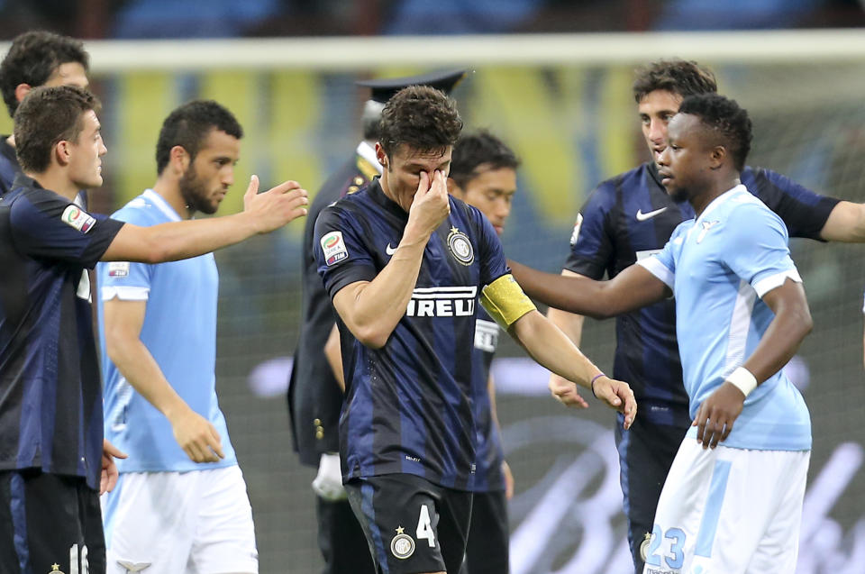 Inter Milan's Javier Zanetti,of Argentina, center, wipes his eyes at the end of the Serie A soccer match between Inter Milan and Lazio at the San Siro stadium in Milan, Italy, Saturday, May 10, 2014. Zanetti will retire after 19 seasons at Inter, and the stadium was sold out as fans packed in to bid farewell to their 40-year-old captain. (AP Photo/Antonio Calanni)