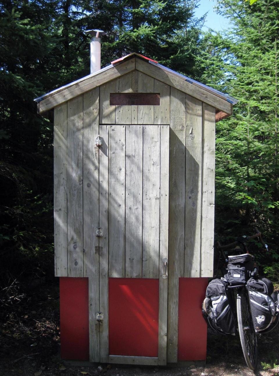 This Aug. 10, 2013 photo shows a wooden outhouse along the P'tit Train du Nord rail trail outside Montreal, Quebec. The rail trail cuts through miles of forest but has plenty of amenities well-spaced along the way. (AP Photo/Calvin Woodward)