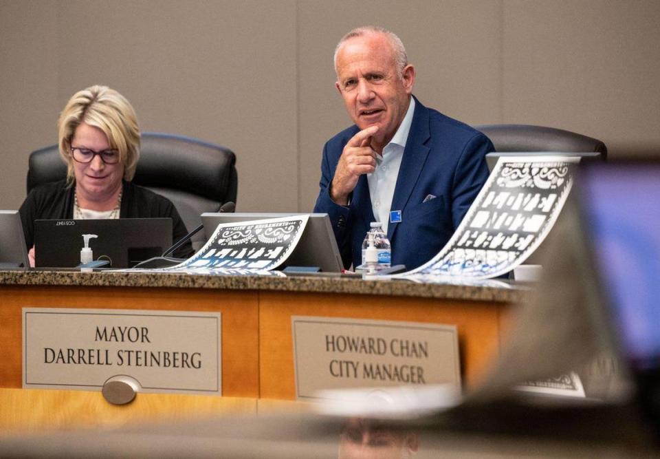 Sacramento Mayor Darrell Steinberg sits with signs that read “Love Not Hate” during a City Council meeting on Tuesday, May 30, 2023. Council members held up the signs when Ryan Messano, who had made antisemitic remarks during public comment at a previous meeting, spoke remotely.