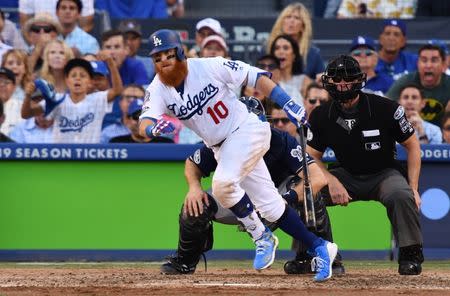 Oct 17, 2018; Los Angeles, CA, USA; Los Angeles Dodgers third baseman Justin Turner (10) hits an RBI single against the Milwaukee Brewers in the seventh inning in game five of the 2018 NLCS playoff baseball series at Dodger Stadium. Mandatory Credit: Robert Hanashiro-USA TODAY Sports