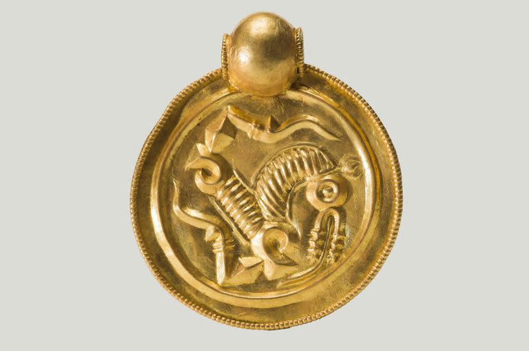 Esta fotografía tomada por Annette Græsli Øvrelid y publicada el 7 de septiembre de 2023 por el Museo de Arqueología y la Universidad de Stavanger (UiS), en el suroeste de Noruega, muestra uno de los nueve colgantes de oro con forma de moneda que forman parte de un tesoro de oro
