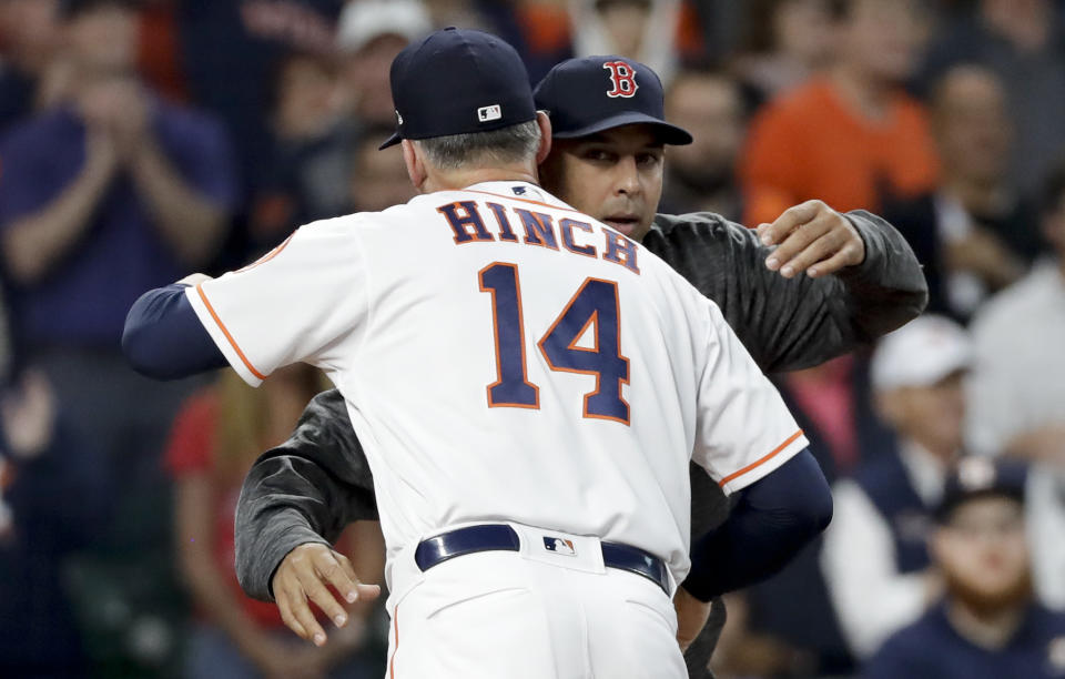 El manager AJ Hinch (izquierda) de los Astros de Houston y su colega Alex Cora de los Medias Rojas de Boston se abrazan previo al tercer juego de la Serie de Campeonato de la Liga Nacional, el martes 16 de octubre de 2018. (AP Foto/David J. Phillip)