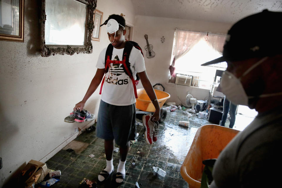 People in face masks begin cleaning out&nbsp;their property.