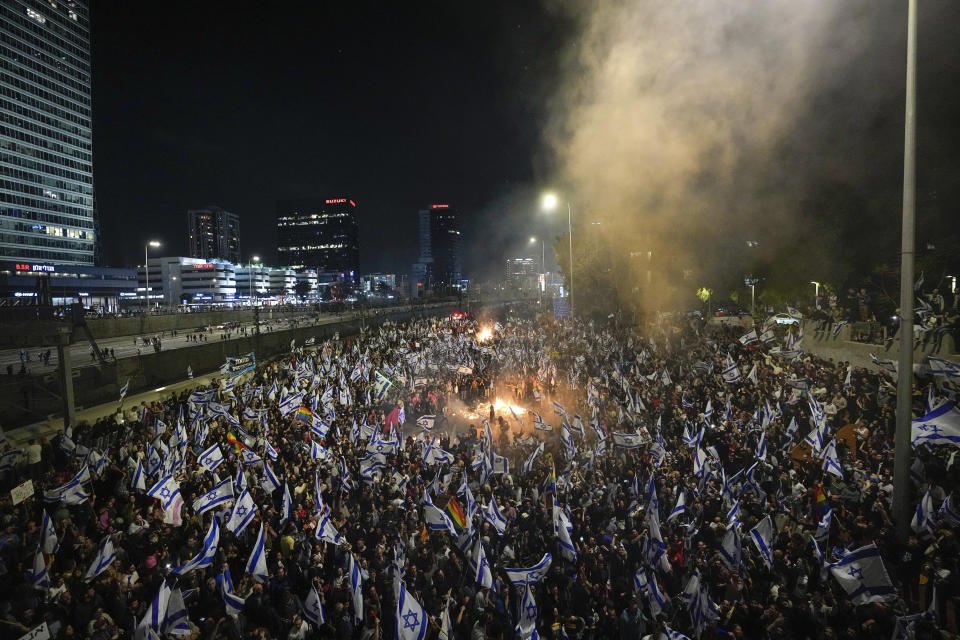 Israelis opposed to Prime Minister Benjamin Netanyahu's judicial overhaul plan set up bonfires and block a highway during a protest moments after the Israeli leader fired his defense minister, in Tel Aviv, Israel, Sunday, March 26, 2023. Defense Minister Yoav Gallant had called on Netanyahu to freeze the plan, citing deep divisions in the country and turmoil in the military. (AP Photo/Ohad Zwigenberg)