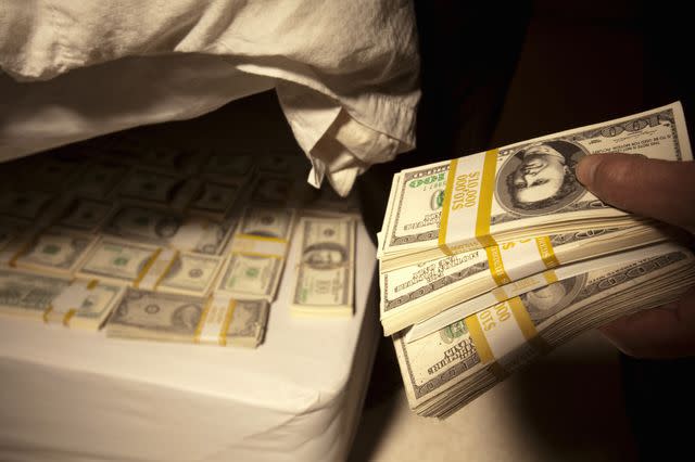 Getty Images Stock image of person hiding money under a mattress