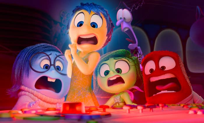 Joy, Fear, Disgust, Sadness, and Anger from Pixar's Inside Out react with alarm in front of a control panel