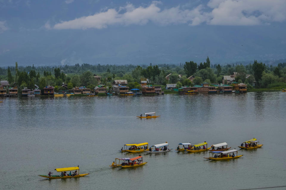 Tourists enjoy boat ride at Dal Lake in Srinagar, Indian controlled Kashmir, Thursday, May 18, 2023. Indian authorities have stepped up security and deployed elite commandos to prevent rebel attacks during the meeting of officials from the Group of 20 industrialized and developing nations in the disputed region next week. (AP Photo/Mukhtar Khan)