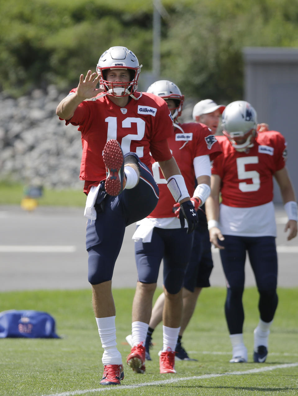 New England Patriots quarterback Tom Brady (12) warms up during an NFL football practice, Wednesday, Sept. 5, 2018, in Foxborough, Mass. Quarterbacks Brian Hoyer, behind center, and Danny Etling (5) stand on the field. (AP Photo/Steven Senne)