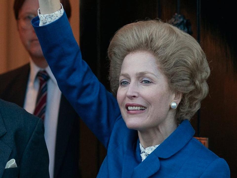 Gillian Anderson as Margaret Thatcher, waving her arm in the air