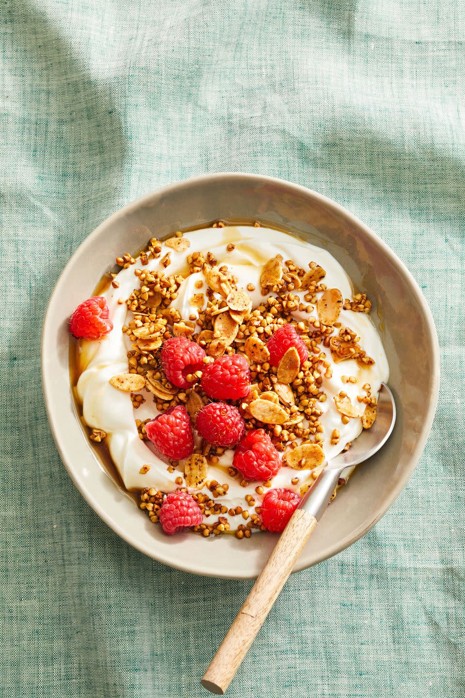 almond buckwheat granola with yogurt and berries in a bowl