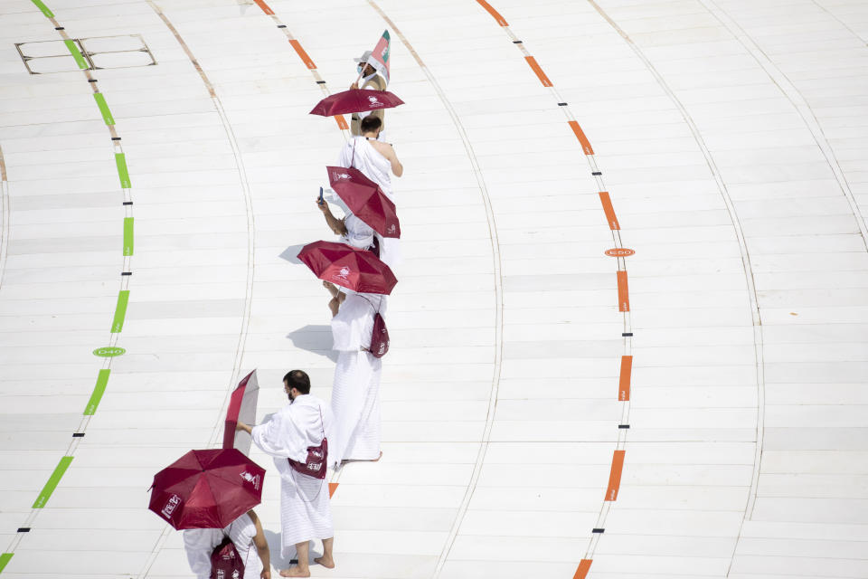 In this photo released by the Saudi Media Ministry, a limited numbers of pilgrims move several feet apart, circling the cube-shaped Kaaba in the first rituals of the hajj, as they keep social distancing to limit exposure and the potential transmission of the coronavirus, at the Grand Mosque in the Muslim holy city of Mecca, Saudi Arabia, Wednesday, July 29, 2020. The hajj, which started on Wednesday, is intended to bring about greater humility and unity among Muslims. (Saudi Media Ministry via AP)