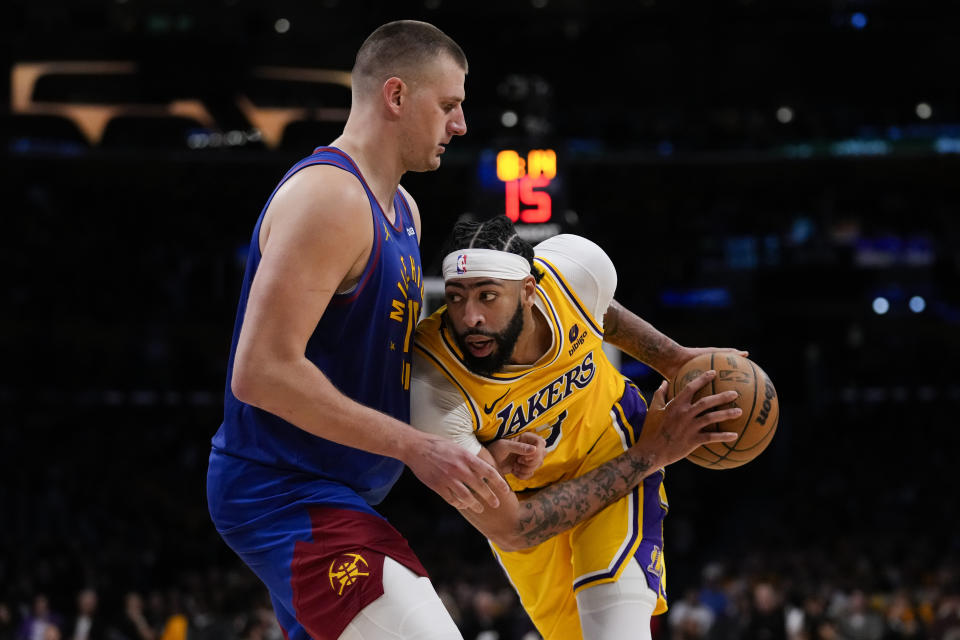 Denver Nuggets center Nikola Jokic (15) defends against Los Angeles Lakers forward Anthony Davis (3) during the second half of Game 3 of an NBA basketball first-round playoff series in Los Angeles, Thursday, April 25, 2024. (AP Photo/Ashley Landis)
