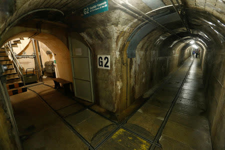 FILE PHOTO: Visitors walk through a tunnel at the former Swiss artillery fortress Reuenthal near the village of Reuenthal, Switzerland July 18, 2015. REUTERS/Arnd Wiegmann/File Photo