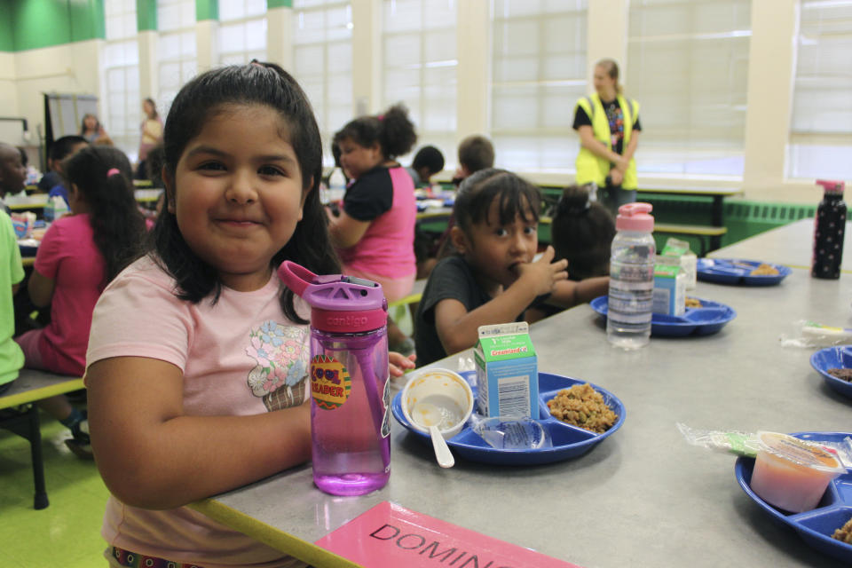 A student posing for a photograph after finishing lunch at Lowell Elementary School in Albuquerque, New Mexico, Aug. 22, 2023. Several states are making school breakfasts and lunches permanently free to all students starting this academic year, regardless of family income, and congressional supporters of universal school meals have launched a fresh attempt to extend free meals for all kids nationwide. (AP Photo/Susan Montoya Bryan)