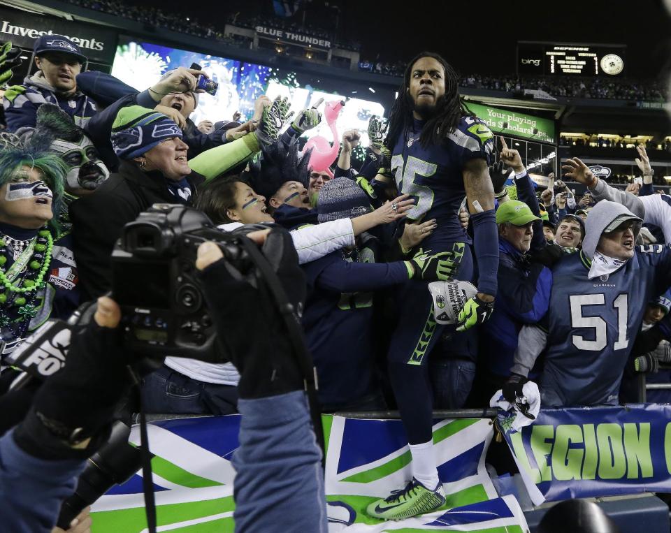 Seattle Seahawks' Richard Sherman celebrates with fans after after the NFL football NFC Championship game against the San Francisco 49ers Sunday, Jan. 19, 2014, in Seattle. The Seahawks won 23-17 to advance to Super Bowl XLVIII. (AP Photo/Elaine Thompson)