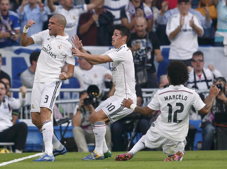 Real Madrid's Pepe (L) celebrates with James Rodriguez (C) and Marcelo after scoring against Barcelona during their Spanish first division "Clasico" soccer match at the Santiago Bernabeu stadium in Madrid October 25, 2014. REUTERS/Juan Medina (SPAIN - Tags: SOCCER SPORT)