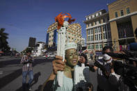 Cambodian-American lawyer Theary Seng, foreground, dressed in the Lady Liberty, talks to the media outside the Phnom Penh Municipal Court in Phnom Penh, Cambodia, Tuesday, June 14, 2022. The Cambodian American lawyer and dozens of members of a now-dissolved opposition party were convicted of treason Tuesday in a trial that was the latest move to tame all opposition to the long-running rule of Prime Minister Hun Sen. (AP Photo/Heng Sinith)