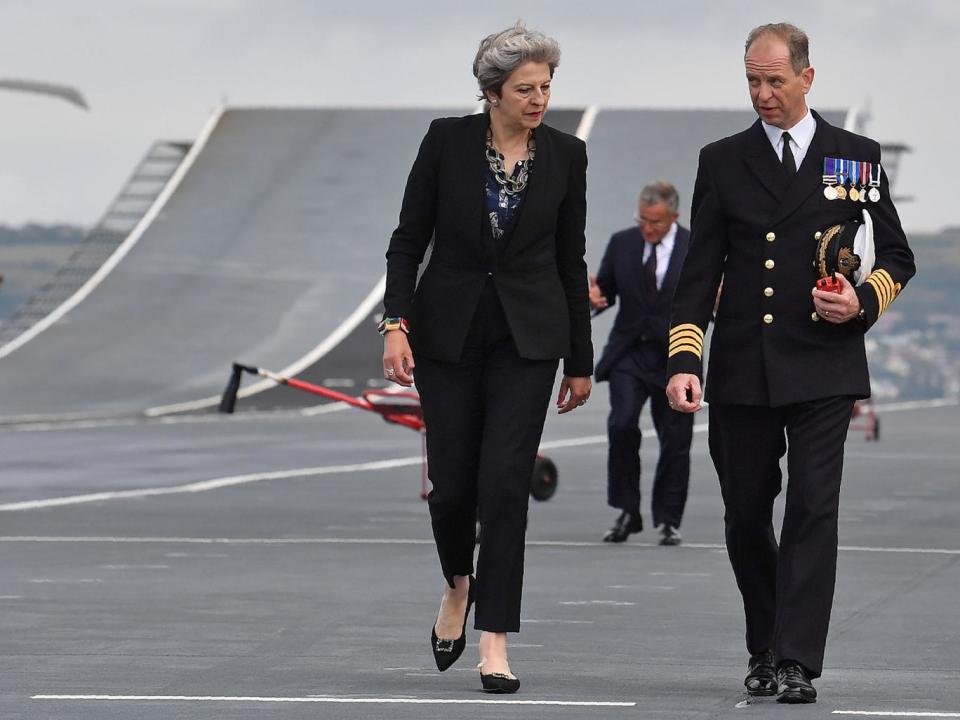 Theresa May talks with Commodore Jerry Kyd (2L), Captain of the 65,000-tonne British aircraft carrier HMS Queen Elizabeth (Getty Images)