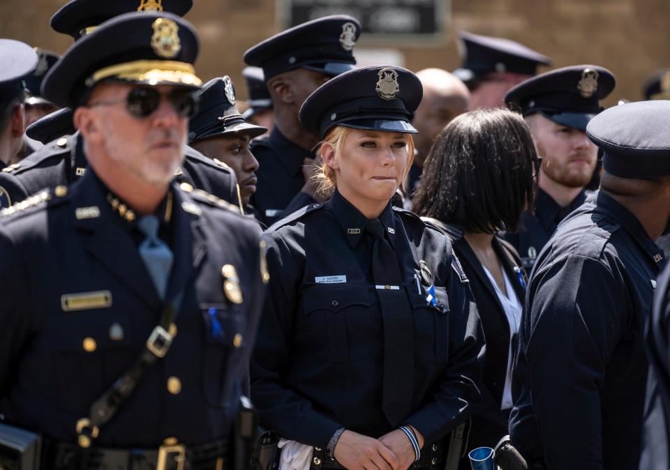 Detroit Police officer Amanda Hudgens, center, stands with other law enforcement officers as they wait for the casket carrying fallen Detroit Police Officer Loren Courts on Monday, July 18, 2022, at the end of his funeral at Greater Grace Temple in Detroit.