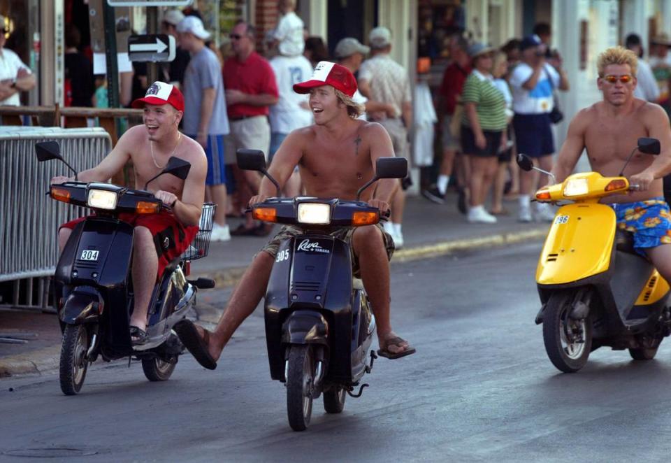 Old Town has turned into a college town as spring breakers converge on Key West in 2003. Here, they ride down Duval Street.