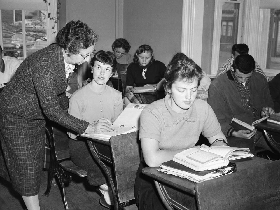 A teacher teaches in an improvised classroom in 1958