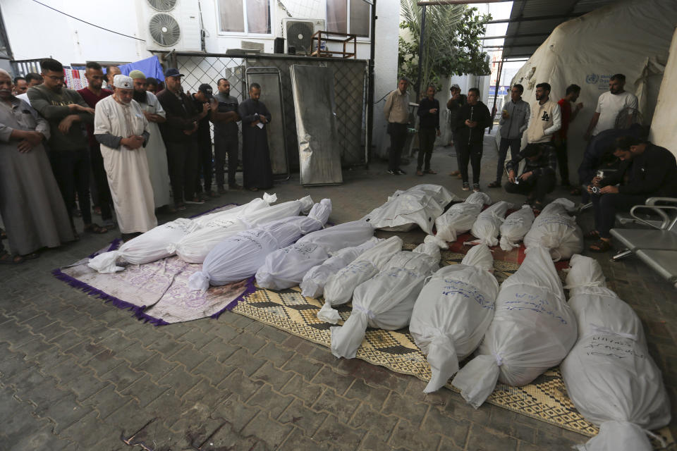 Palestinos rezan junto a los cadáveres de los miembros de la familia Hijazi, muertos en un bombardeo israelí sobre la Franja de Gaza, el 10 de noviembre de 2023, en Rafah. (AP Foto/Hatem Ali)