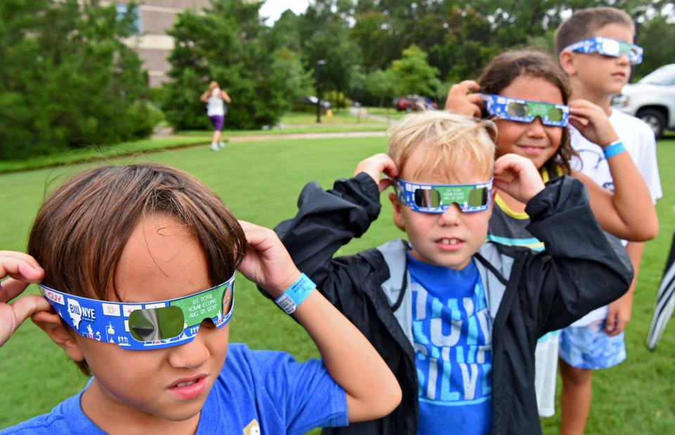 Luke Nicolay, 6, Finley Watson, 7, Curren Nicolay, 8, and Wyland Lamphere, 8, try out their glasses as they wait on the Coxwell Amphitheater at UNF in hopes of viewing the eclipse. On Monday August 21, 2017 the UNF Physics Department, Student Union and Office of Campus Life hosted an eclipse viewing party 1:30 to 3:30 p.m. Monday, Aug. 21, at Coxwell Amphitheater, near the Student Union on the campus of the University of North Florida. (Bob Mack/Florida Times-Union)