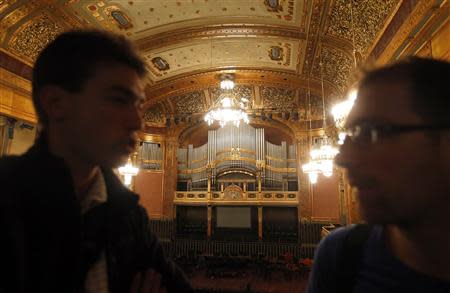 Two men talk above the reopened large concert hall of the Liszt Academy music school in Budapest October 21, 2013. REUTERS/Laszlo Balogh