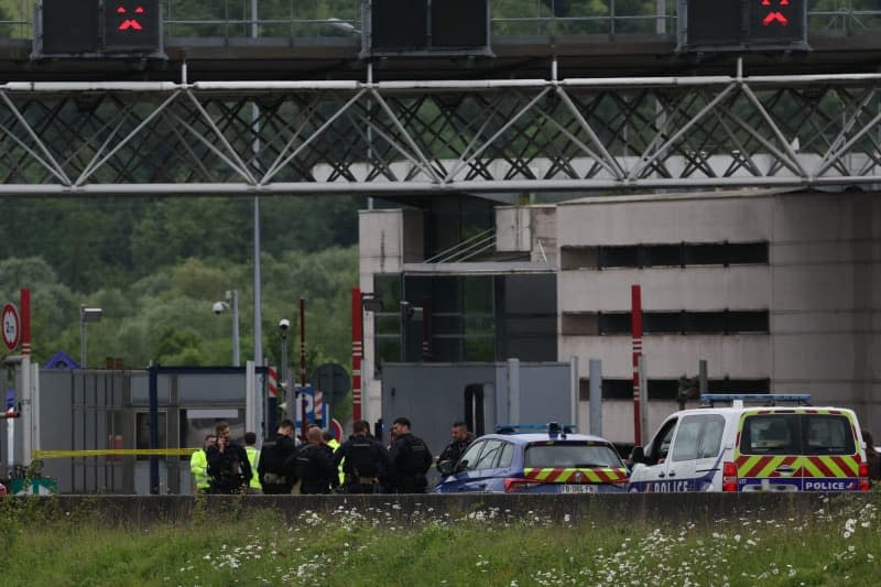 Police officers work at the site of a ramming attack that took place late this morning at a toll booth in Incarville in the Eure region of northern France. Police officers were killed and others injured in an attack on a prisoner transport in the north of France. Alain Jocard/AFP/dpa