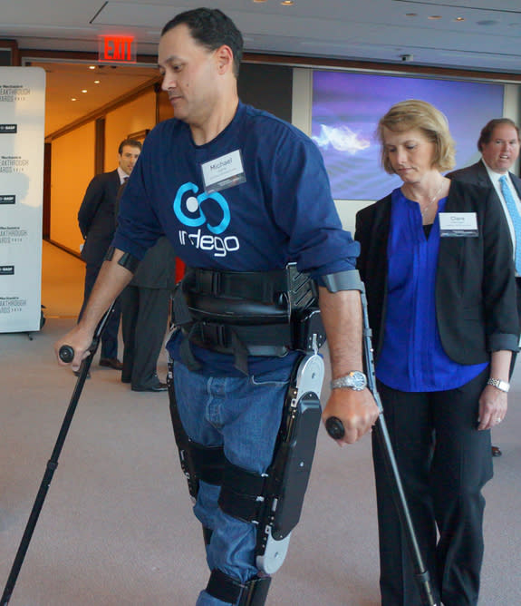Michael Gore and trainer Clare Hartigan walk through the 2013 Popular Mechanics Breakthrough awards. Gore, a T10 complete paraplegic, is wearing the Indego Exoskeleton, which allows him to walk.