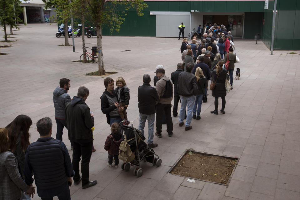 People line up outside a polling station to cast their vote for the general election in Barcelona, Spain, Sunday, April 28, 2019. Galvanized by the Catalan crisis, Spain's far right is set to enter Parliament for the first time in decades while the Socialist government tries to cling on to power in Spain's third election in four years. (AP Photo/Emilio Morenatti)