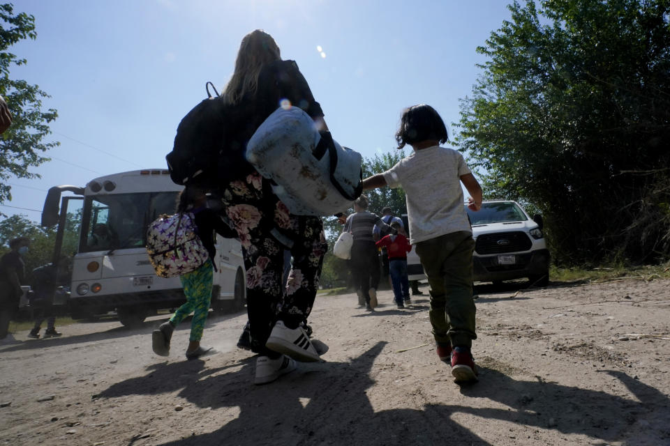 ARCHIVO - Una familia de migrantes venezolanos se dirige hacia un autobús de la Patrulla Fronteriza después de que cruzaran con otras personas de México hacia Estados Unidos y se entregaran a las autoridades, el miércoles 17 de junio de 2021, en Del Rio, Texas. (AP Foto/Eric Gay, archivo)